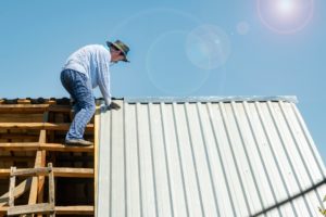carpenter repairs the roof of a house in hot weather
